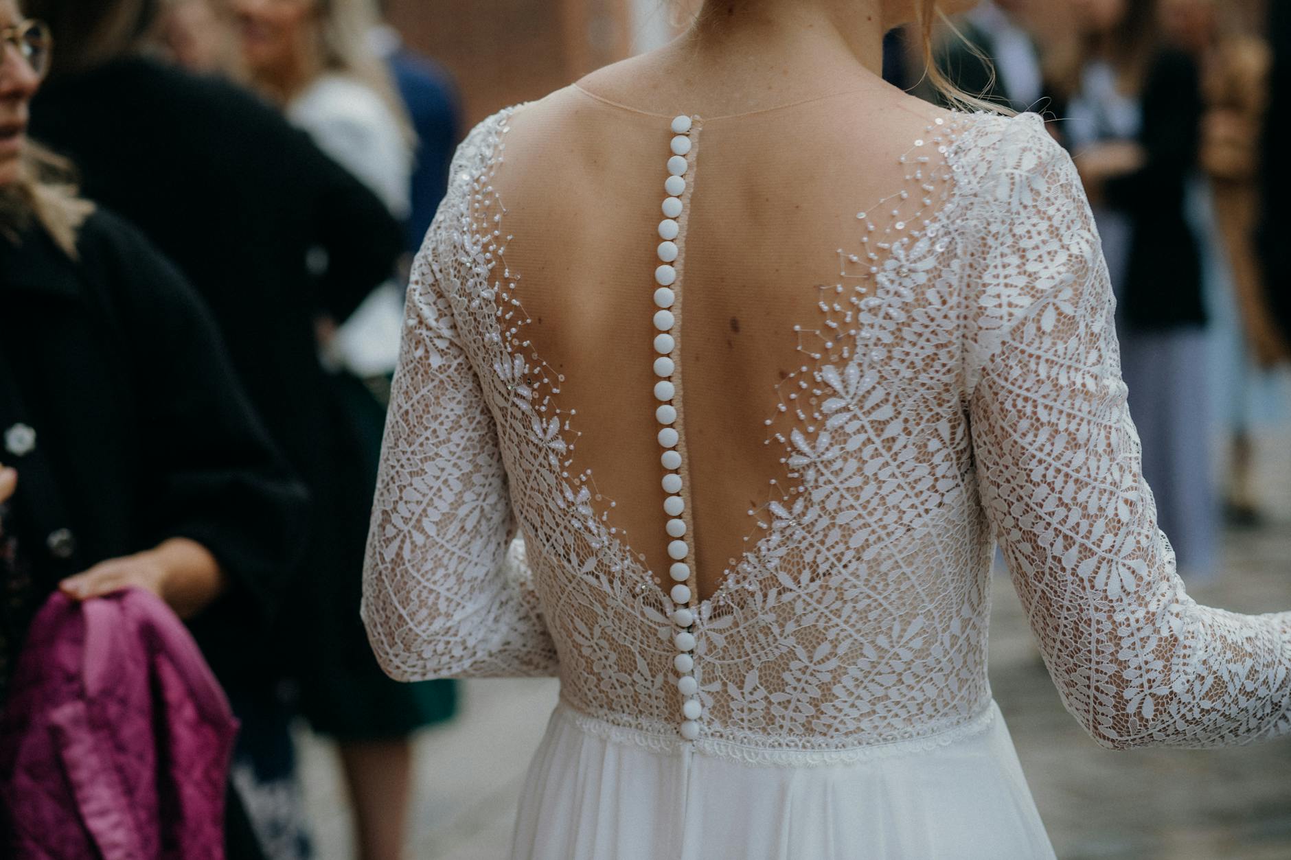 back view of a woman in white jewelry and wedding dress