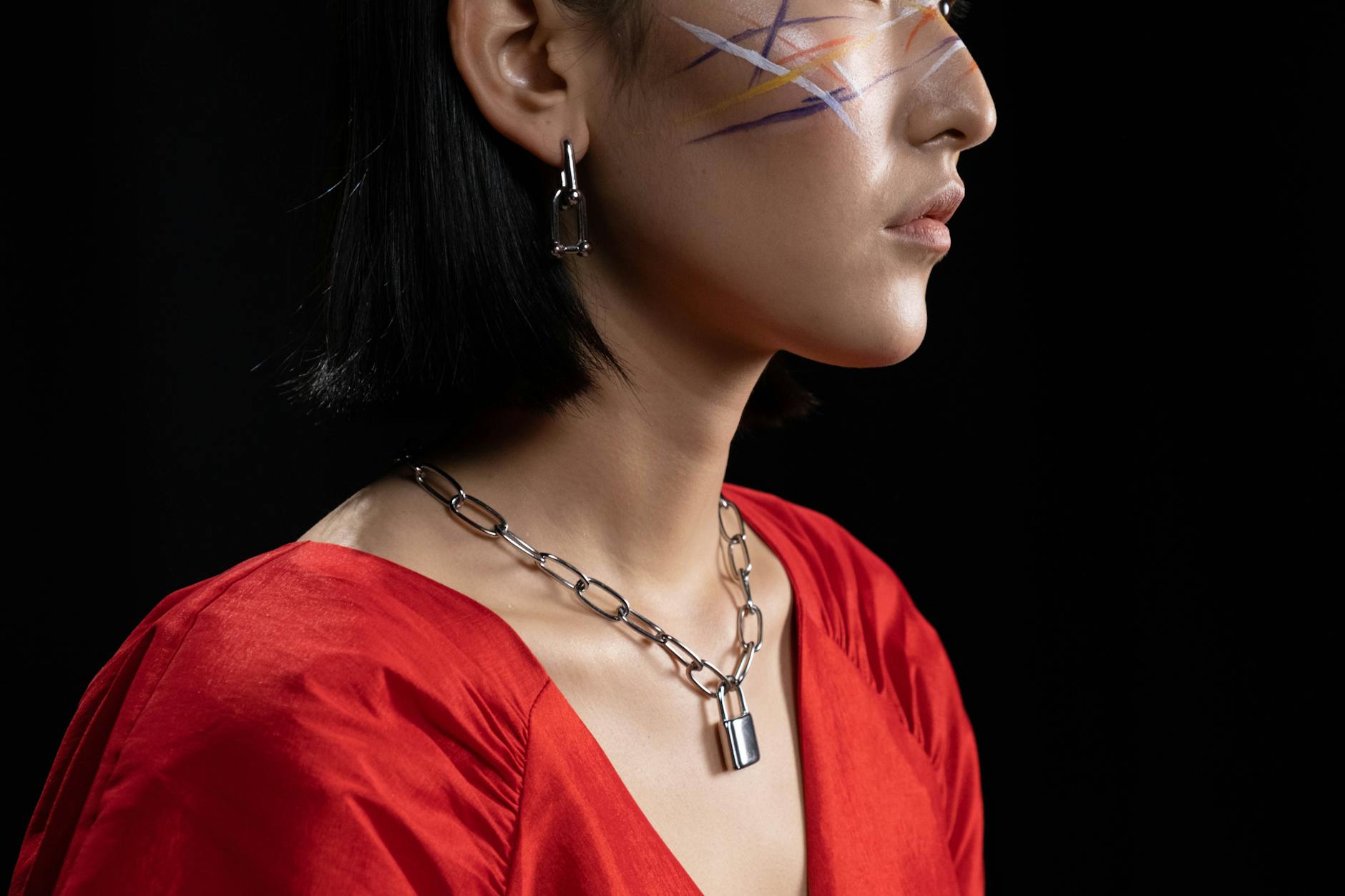 woman with face paint wearing a silver chain necklace jewelry and red dress